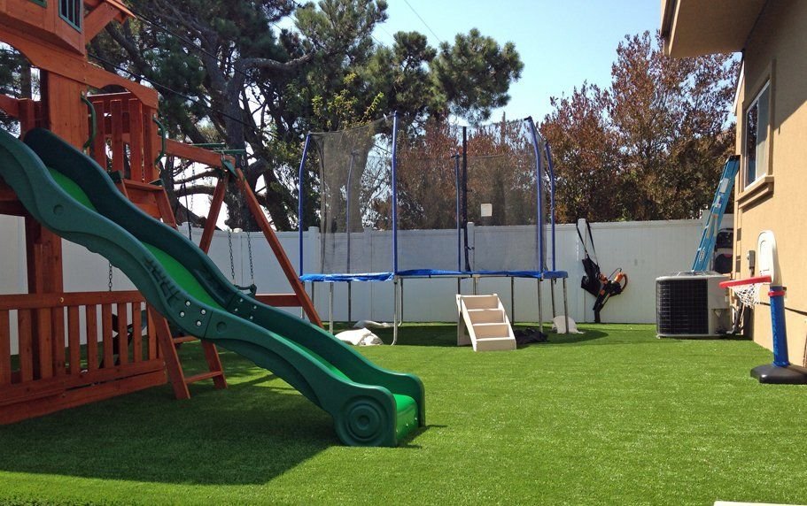 a backyard playset on a freshly installed playground artificial turf